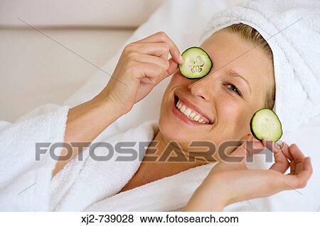 Woman smiling with cucumber on her eyes View Large Photo Image Stock Photo - Woman smiling with cucumber on her eyes. Fotosearch