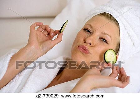 Woman smiling with cucumber on her eyes View Large Photo Image Stock Photo - Woman smiling with cucumber on her eyes. Fotosearch