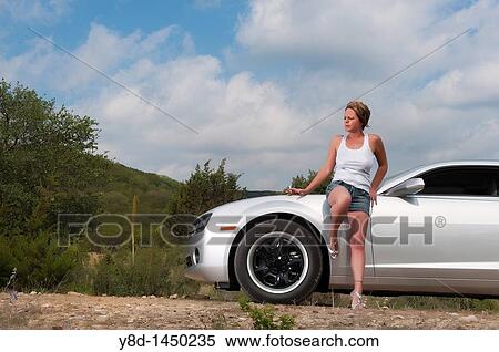 Stock Photography - Woman smoking a cigarette at sports car. Fotosearch