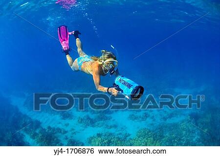 Stock Photograph - woman snorkeler with housed underwater video camera, diving over coral reef, Kiholo Bay, Kohala Coast, Big Island, Hawaii, USA, Pacific Ocean. Fotosearch