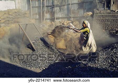 Stock Image - Woman sorting stones used for construction work. Rajasthan, India.. Fotosearch