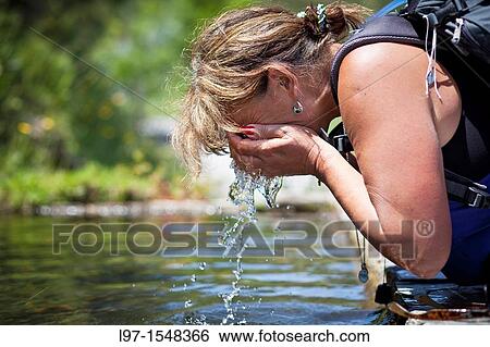 Woman splashing her face with water on the Camino de Santiago View Large Photo Image Stock Photograph - Woman splashing her face with water on the Camino de Santiago. Fotosearch