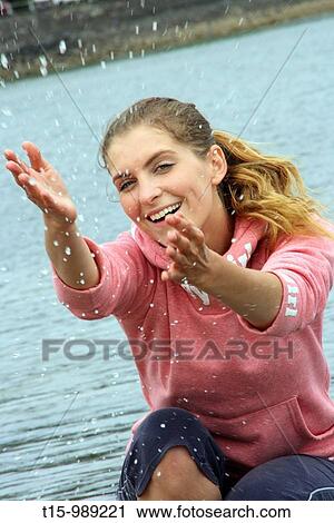 Woman splashing water by the beach View Large Photo Image Stock Image - Woman splashing water by the beach. Fotosearch