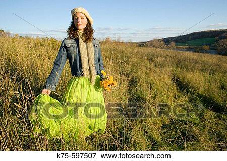 Woman standing in field on hilltop View Large Photo Image Stock Photo - Woman standing in field on hilltop. Fotosearch