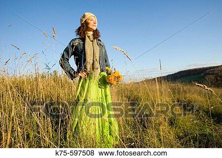 Woman standing in field on hilltop View Large Photo Image Stock Photo - Woman standing in field on hilltop. Fotosearch