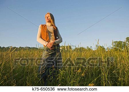 Stock Photograph - woman standing in field. Fotosearch