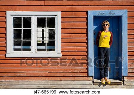 Woman standing in front of a wooden house. View Large Photo Image Stock Photo - Woman standing in front of a wooden house.. Fotosearch