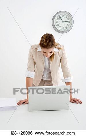 Stock Photograph - Woman standing in front of the laptop. Fotosearch