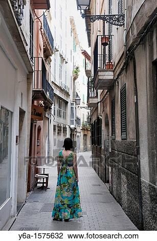 Stock Image - Woman standing in narrow alley in old town Palma De Mallorca, Spain, Europe. Fotosearch