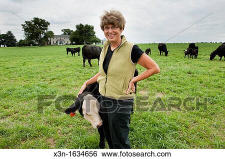 Woman standing in pasture with Angus beef cattle View Large Photo Image Stock Photograph - Woman standing in pasture with Angus beef cattle. Fotosearch