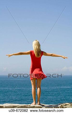 Woman standing on a wall overlooking the sea. Shot from behind. Sydney, Australia View Large Photo Image Stock Image - Woman standing on a wall overlooking the sea. Shot from behind. Sydney, Australia. Fotosearch