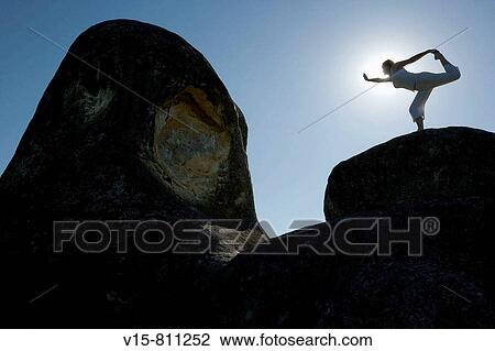 Stock Image - woman standing on rock. Fotosearch