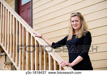 Stock Photo - Woman standing on stairs whith handrail. Fotosearch