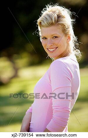 Woman standing outdoors looking at camera View Large Photo Image Picture - Woman standing outdoors looking at camera. Fotosearch