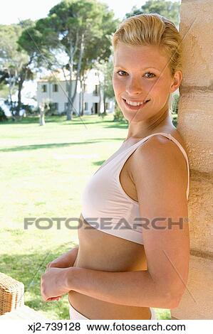 Stock Photo - Woman standing outdoors looking at camera. Fotosearch