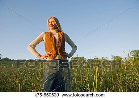 woman standing with hands on hips in field View Large Photo Image Stock Photo - woman standing with hands on hips in field. Fotosearch