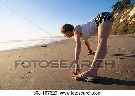 Woman stretching at the beach View Large Photo Image Stock Photo - Woman stretching at the beach. Fotosearch