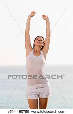 Stock Photo - Woman stretching by the sea. Fotosearch
