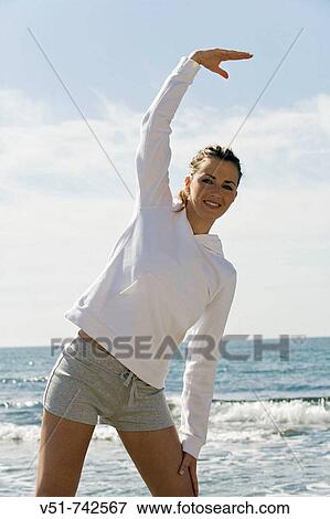 Stock Photo - woman stretching by the sea. Fotosearch