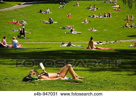 Stock Image - Woman sunbathing in Sinebrychoff park in Helsinki Finland Europe. Fotosearch