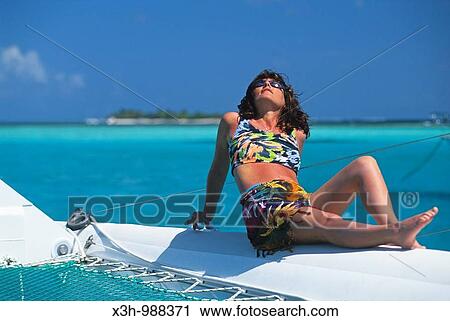 Stock Image - woman sunbathing on catamaran, Tobago Cays, Grenadines islands, Saint Vincent and the Grenadines, Winward Islands, Lesser Antilles, Caribbean Sea. Fotosearch