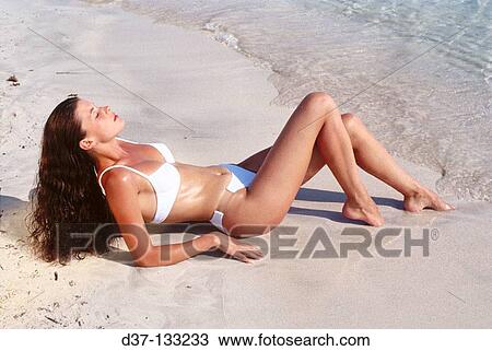 Woman sunbathing on the beach View Large Photo Image Stock Image - Woman sunbathing on the beach. Fotosearch