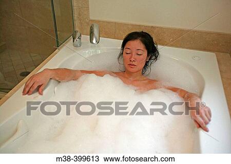 Stock Image - Woman taking a bubble bath. Fotosearch