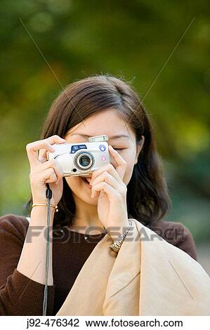 Woman taking photo (focus on camera in hand ) Tokyo, Japan. View Large Photo Image Stock Image - Woman taking photo (focus on camera in hand ) Tokyo, Japan.. Fotosearch