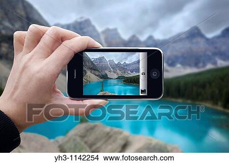 Woman taking picture using an iPhone View Large Photo Image Picture - Woman taking picture using an iPhone. Fotosearch