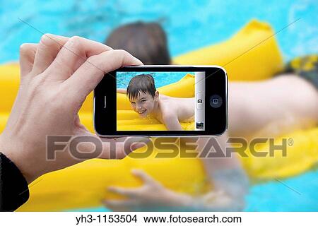 Woman taking picture using an iPhone View Large Photo Image Picture - Woman taking picture using an iPhone. Fotosearch