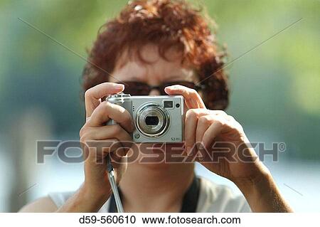 Stock Image - Woman taking picture with digital camera. Fotosearch