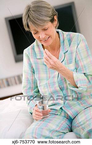 Stock Image - Woman taking pill. Fotosearch