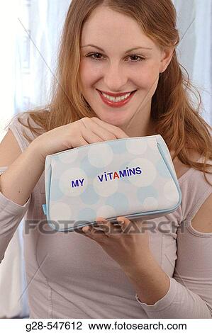 Stock Image - Woman taking vitamins. Fotosearch
