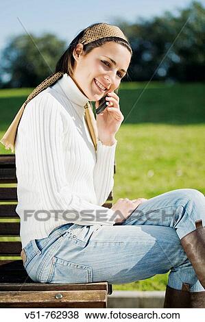 woman talking on the mobile in a park View Large Photo Image Stock Photo - woman talking on the mobile in a park. Fotosearch