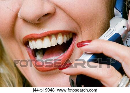Stock Photo - Woman talking with cellular phone and laughing. Fotosearch