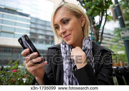 Woman texting outdoors View Large Photo Image Stock Photo - Woman texting outdoors. Fotosearch