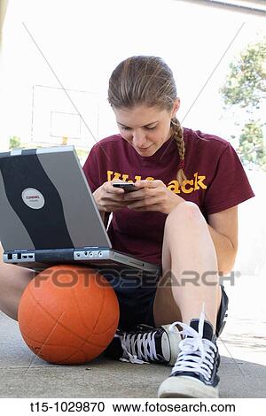 woman texting with a laptop on top of a basketball View Large Photo Image Stock Image - woman texting with a laptop on top of a basketball. Fotosearch
