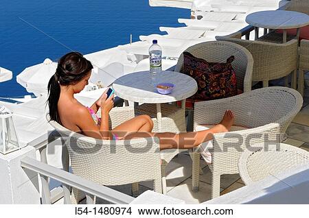 Woman texts message Santorini Greece Island Mediterranean Aegean View Large Photo Image Picture - Woman texts message Santorini Greece Island Mediterranean Aegean. Fotosearch