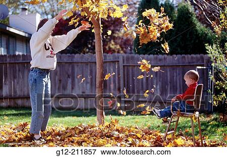 Woman throwig leaves on toddler. Idaho. USA View Large Photo Image Stock Photo - Woman throwig leaves on toddler. Idaho. USA. Fotosearch
