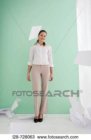 Stock Image - Woman throwing sheets of papers in air. Fotosearch