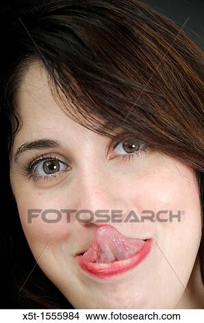 Woman touches nose with tongue View Large Photo Image Picture - Woman touches nose with tongue. Fotosearch