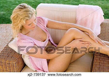 Woman touching her legs View Large Photo Image Stock Photo - Woman touching her legs. Fotosearch