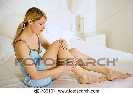 Woman touching her legs View Large Photo Image Stock Photo - Woman touching her legs. Fotosearch