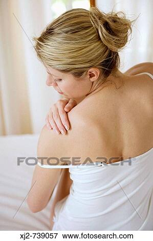 Woman touching her shoulder View Large Photo Image Stock Photo - Woman touching her shoulder. Fotosearch