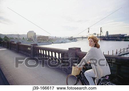 Stock Photo - Woman touring across bridges at sunset. Portland. Oregon. USA. Fotosearch