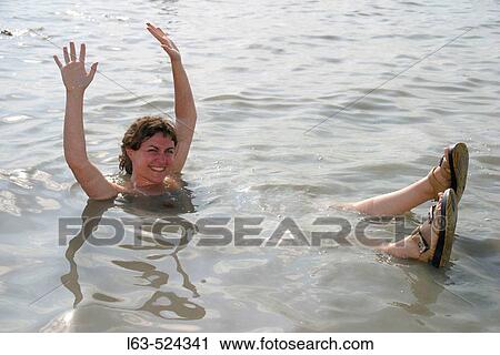 Stock Image - Woman tourist during a bath. Dead Sea. Jordan.. Fotosearch