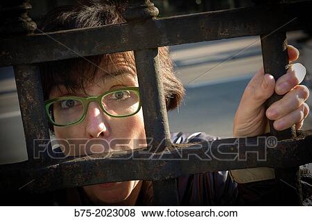 Woman trapped behind a fence View Large Photo Image Stock Photo - Woman trapped behind a fence. Fotosearch