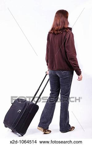 Woman traveller pulling a trolley case Isolated View Large Photo Image Picture - Woman traveller pulling a trolley case Isolated. Fotosearch
