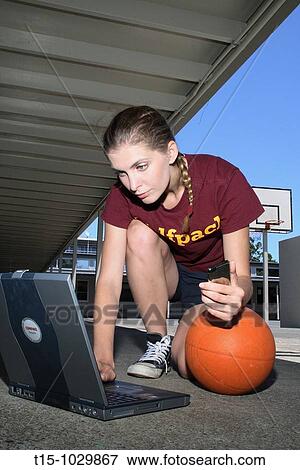 woman using a laptop in a basketball court View Large Photo Image Stock Photo - woman using a laptop in a basketball court. Fotosearch