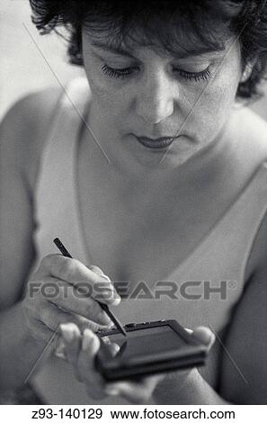 Woman using a Personal Digital Assistant View Large Photo Image Stock Photo - Woman using a Personal Digital Assistant. Fotosearch